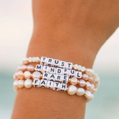 A bead bracelet from Little Words Project that reads, Mindful. Designed from freshwater pearls.