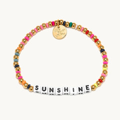 A gold beaded bracelet from Little Words Project®. With the word "Shunshine".