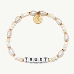 Hand-crafted, freshwater pearl beaded bracelet from Little Words Project. The bracelet reads, TRUST.