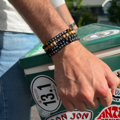 Black bead bracelet from Little Words Project that reads, "Family."