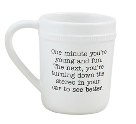 This Mud Pie coffee mug reads, "one minute you're young and fun. The next, you're turning dow the stereo in your car to see better."