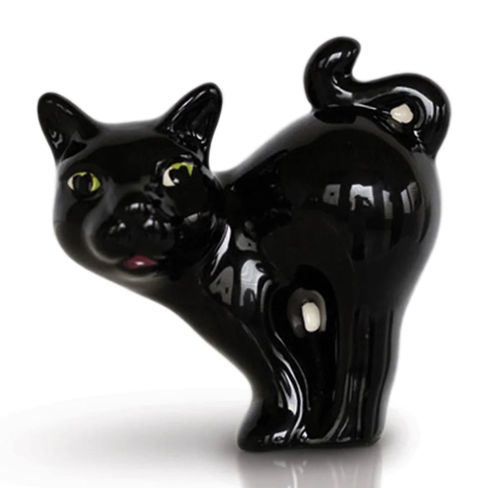 A black cat with green eyes in a perched position, from Nora Fleming Mini collection.