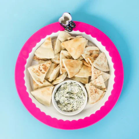 Nora Fleming Band Together Pink (Pink silicone band) around a white platter full of snacks.