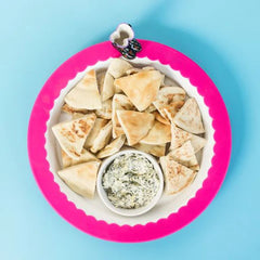Nora Fleming Band Together Pink (Pink silicone band) around a white platter full of snacks.