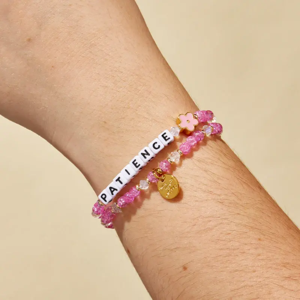 Pink bead bracelet from Little Words Project that reads, "Patience", with a pink flower charm.