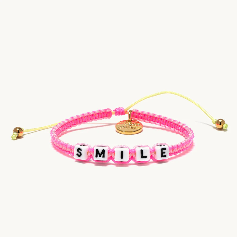 A pink woven bracelet that reads 'smile'.