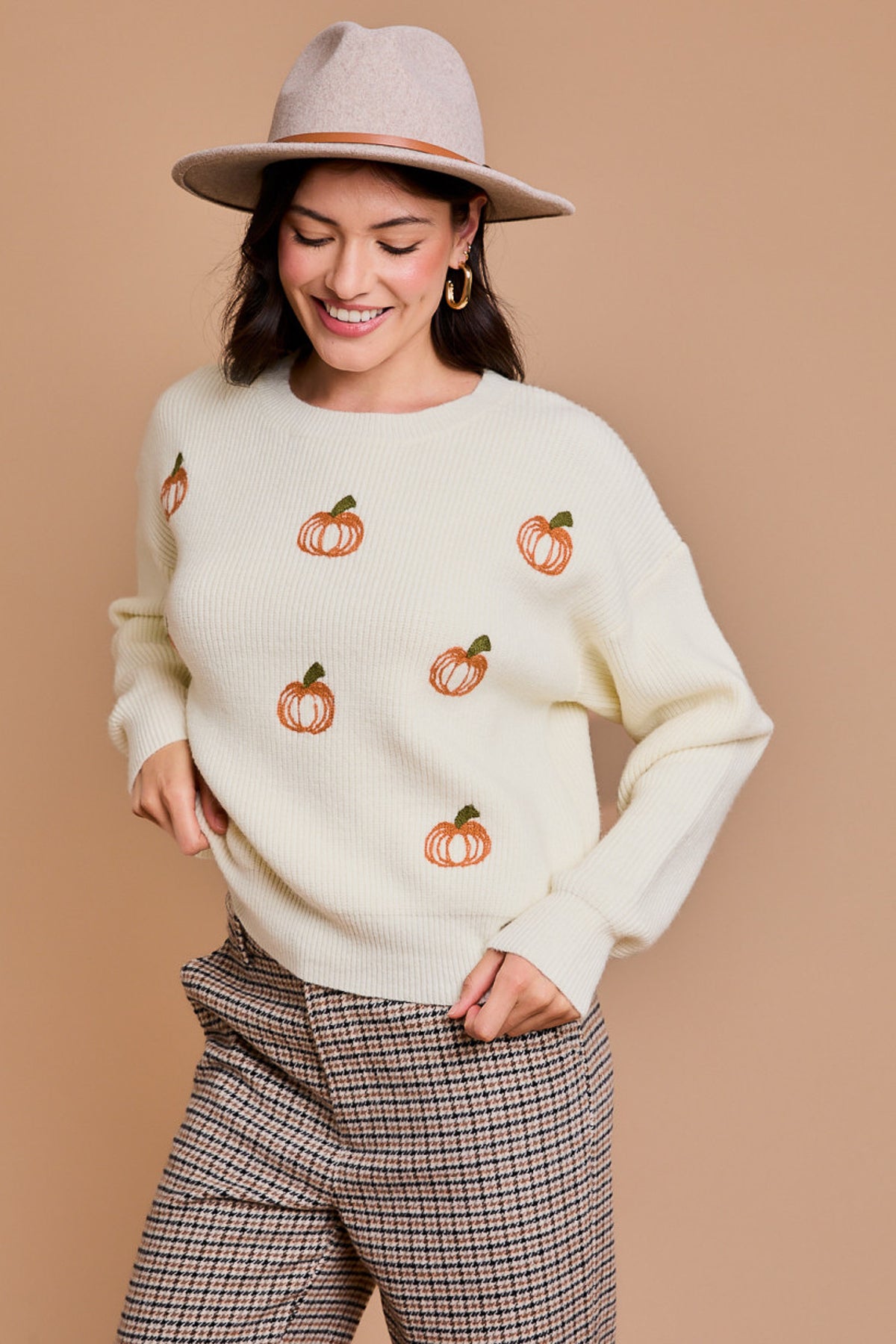 White pullover sweater with orange pumpkins across the front.