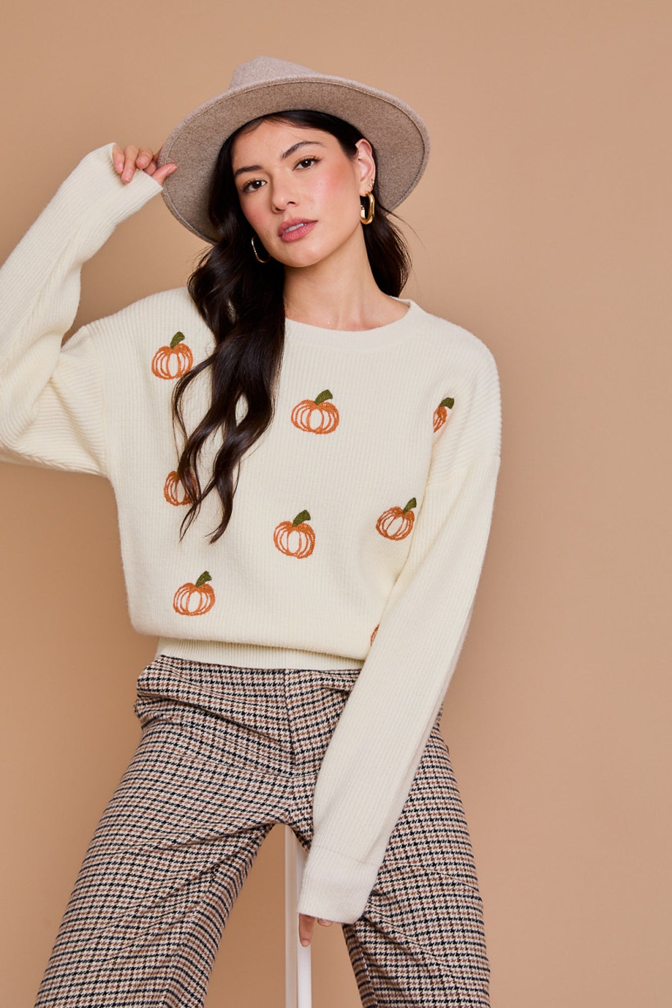 White pullover sweater with orange pumpkins across the front.