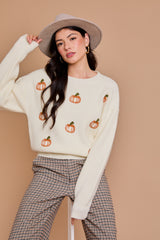 White pullover sweater with orange pumpkins across the front.