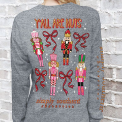 Long sleeve t-shirt with 4 Christmas nutcrackers and the phrase, "Y'ALL ARE NUTS." The Simply Southern brand logo is at the bottom of the shirt, and on the right sleeve.