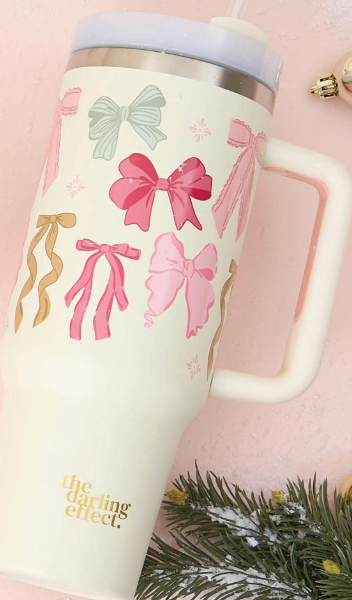 The Darling Effect 40 oz Take Me Everywhere Tumbler in cream with multi colored Christmas bows, and The Darling Effect logo.