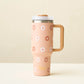 The Darling Effect 40 oz Take Me Everywhere Tumbler in color tan, with brown and white flowers, and a gold The Darling Effect logo.