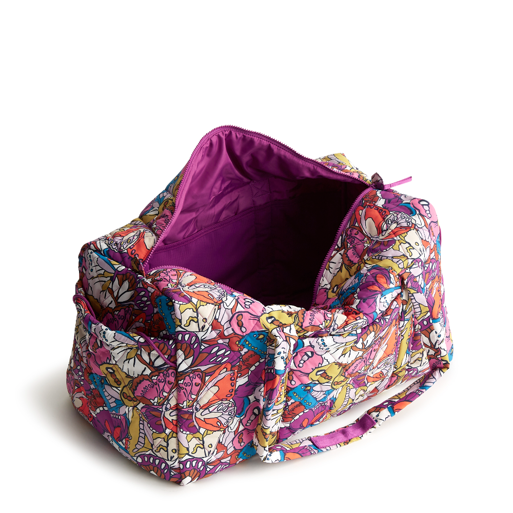 A large duffel bag designed by Vera Bradley in the colors pink, yellow, and blue. The bag is designed with nylon fabric.