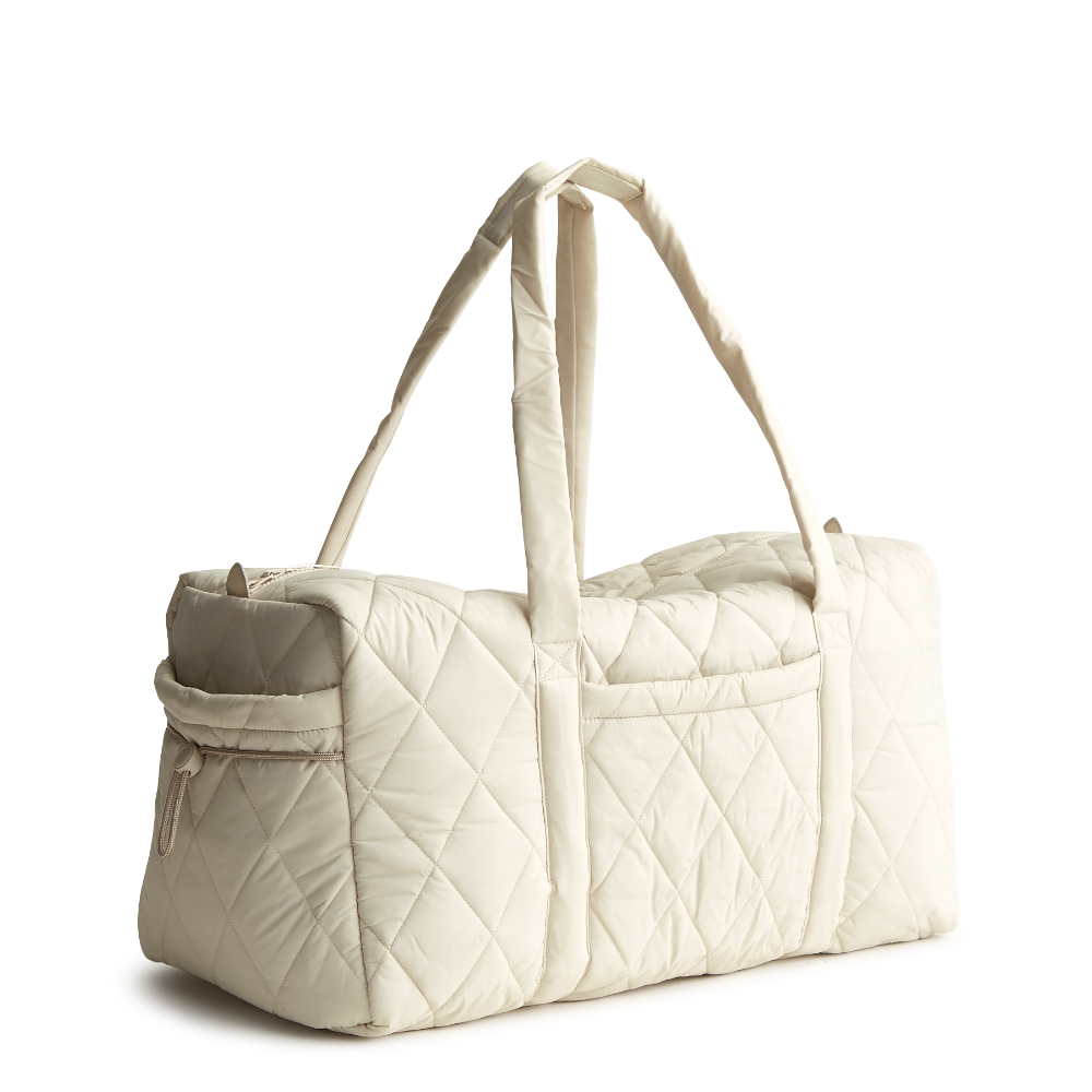 A large duffel bag designed by Vera Bradley in the color white. The bag is designed with nylon fabric.