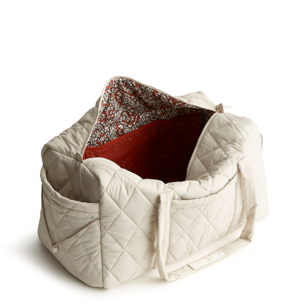 A large duffel bag designed by Vera Bradley in the color white. The bag is designed with nylon fabric.