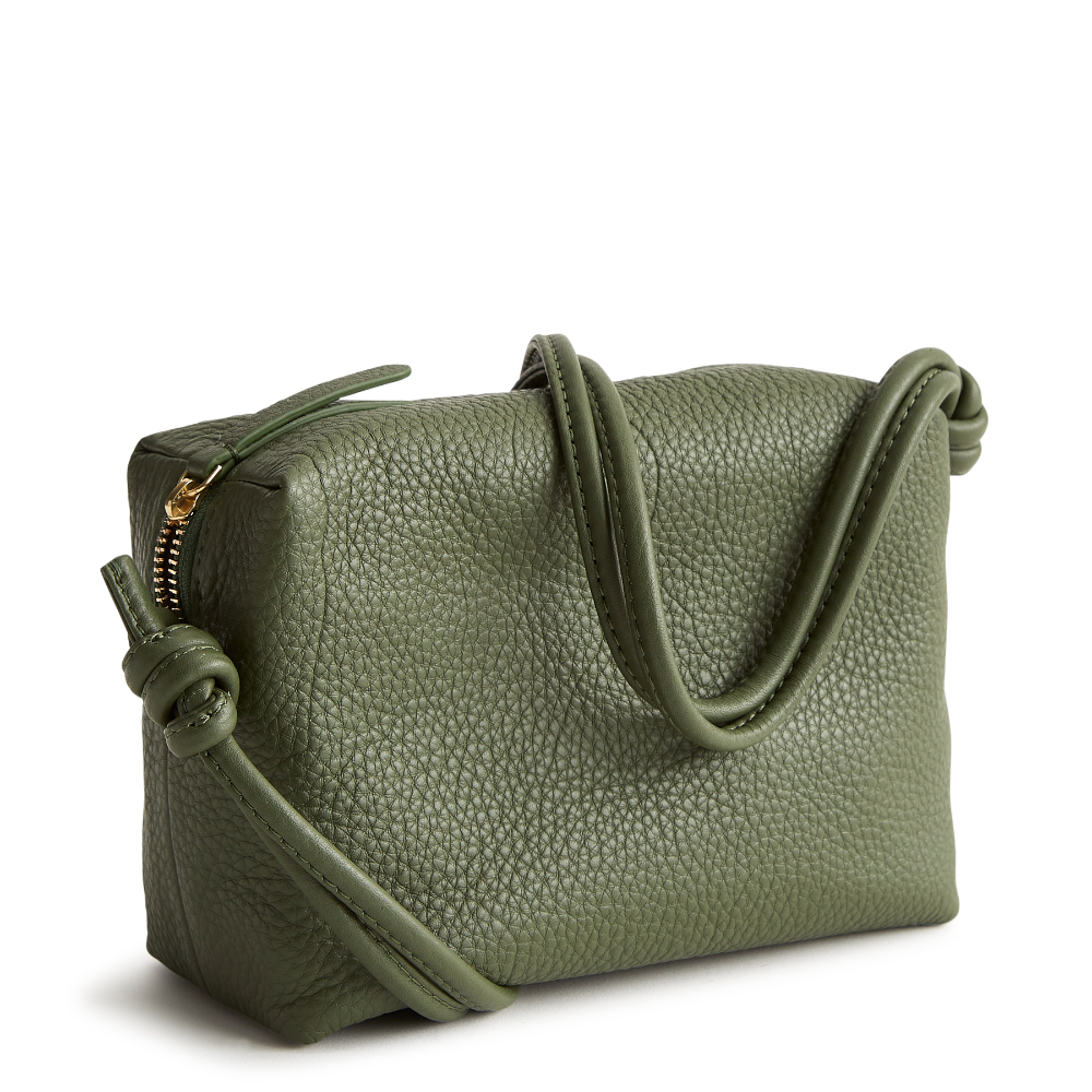 A leather crossbody purse in the color green, designed by Vera Bradley from the Vera Bradley New Day launch. This crossbody is shown in the Vera Bradley pattern Bronze Green.