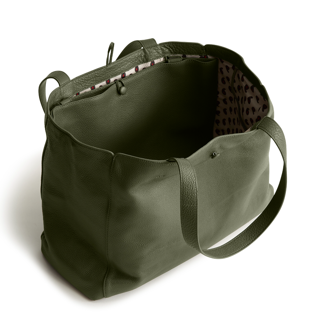 A green color tote bag from Vera Bradley New Day launch. The tote bag is made out of leather, and is shown in the Vera Bradley Pattern Bronze Green.