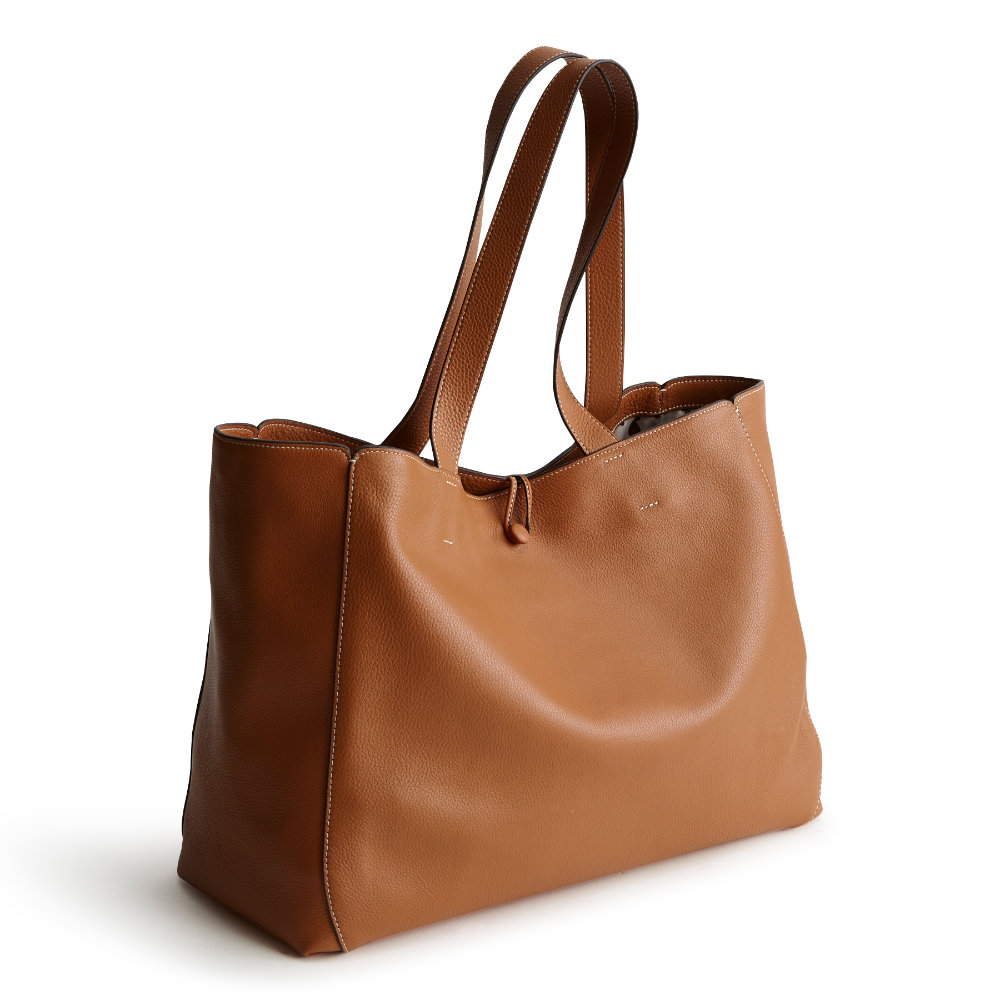 A tan color tote bag from Vera Bradley New Day launch. The tote bag is made out of leather, and is shown in the Vera Bradley Pattern Roasted Pecan.