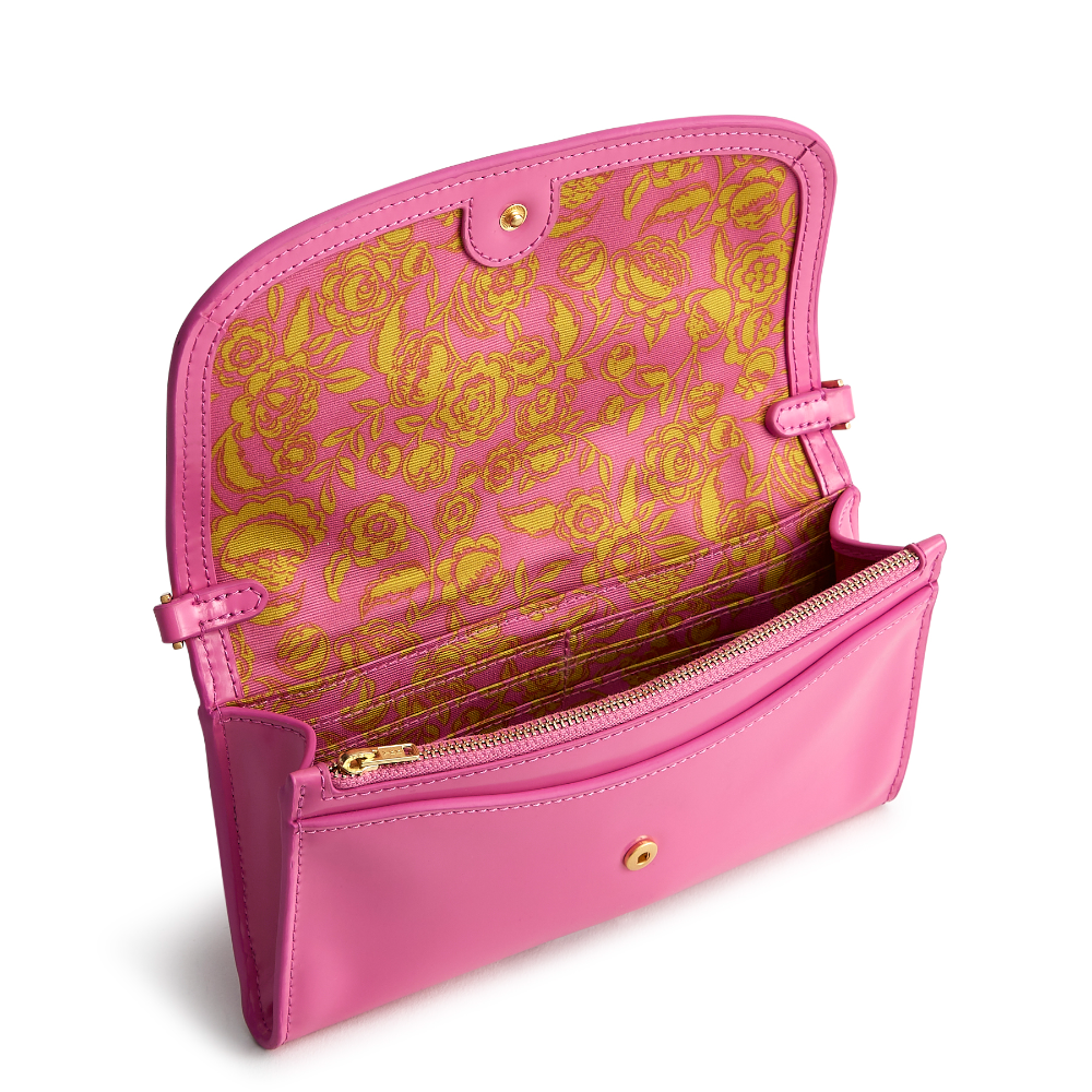 A Vera Bradley Wildwood Wallet Crossbody in Patent Faux Leather. Shown in the color pink.