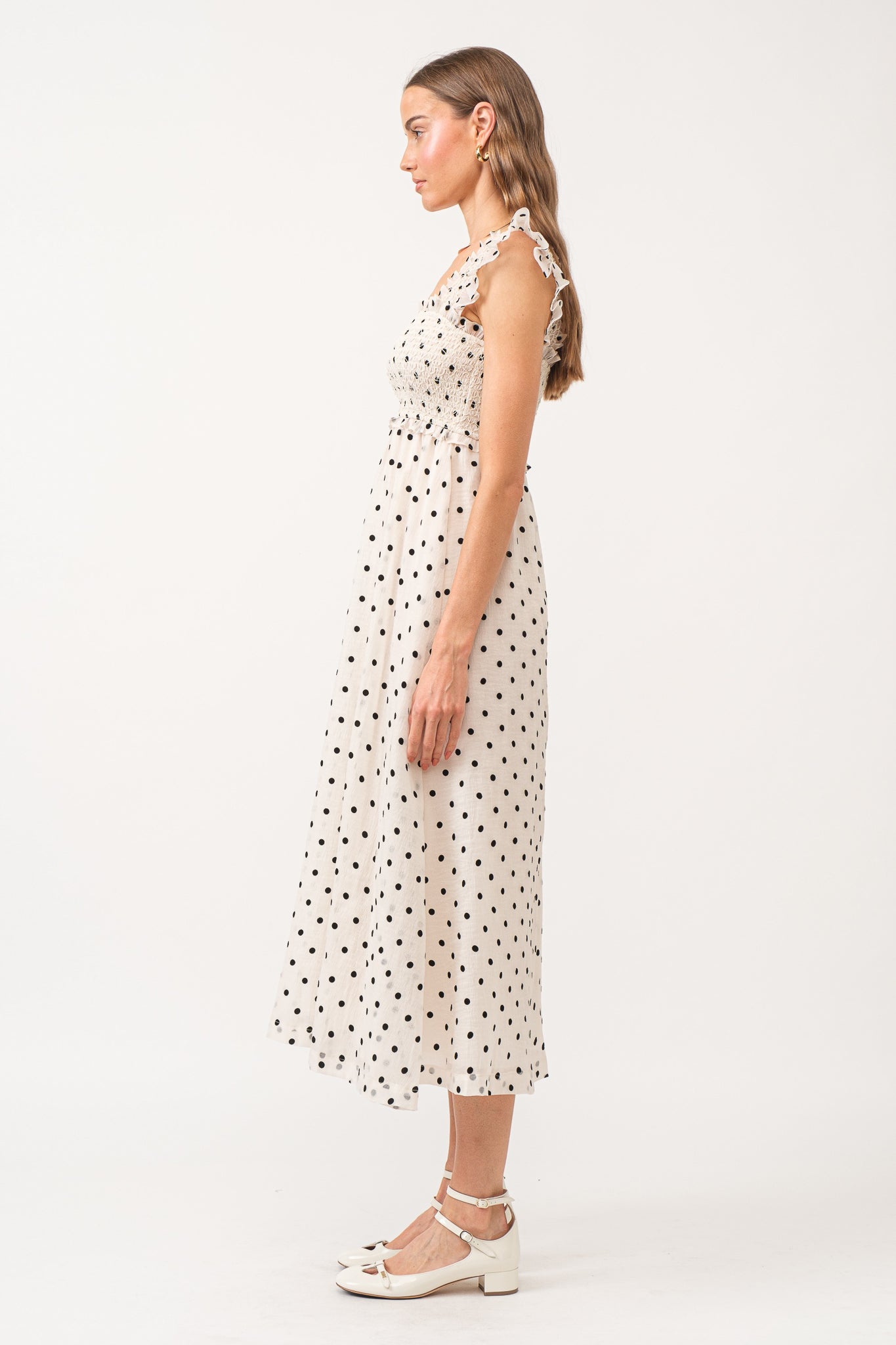 White midi dress with no sleeves, with black polkadots all over.