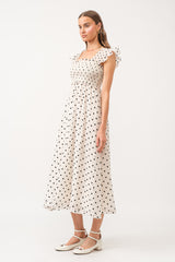 White midi dress with no sleeves, with black polkadots all over.