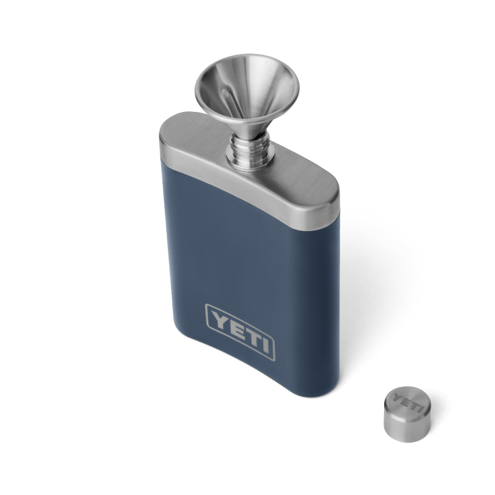 A navy blue flask, with a silver top, and silver funnel for easy pouring. Showing a silver YETI logo on the front.