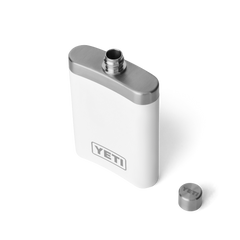 A white flask with a silver top, with the lid off, and an all silver YETI logo no the front of the flask.