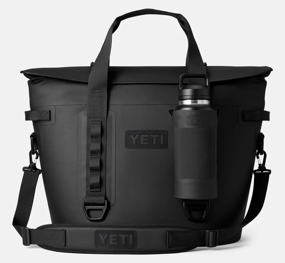 The new YETI Hopper M30 Soft cooler in the color black, with a Rambler bottle attached to the front.