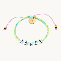 A woven bracelet in the color green, that reads 'happy'.
