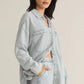 Z Supply model with black hair, wearing the All Day Knit Denim Jacket. The jacket features 6 front buttons, two chest pockets, and a collared top.