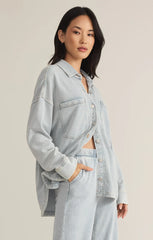 Z Supply model with black hair, wearing the All Day Knit Denim Jacket. The jacket features 6 front buttons, two chest pockets, and a collared top.