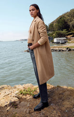 Tan colored mason coat from the brand Z-Supply. The coat has one button and it's length goes past the knees.