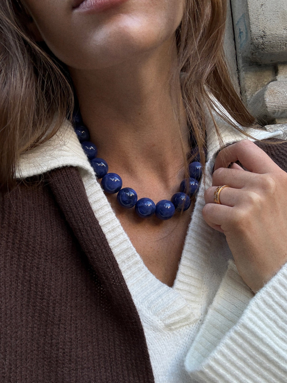 BaubleBar Jane Beaded Necklace in Blue worn with a white V-neck top and brown cardigan