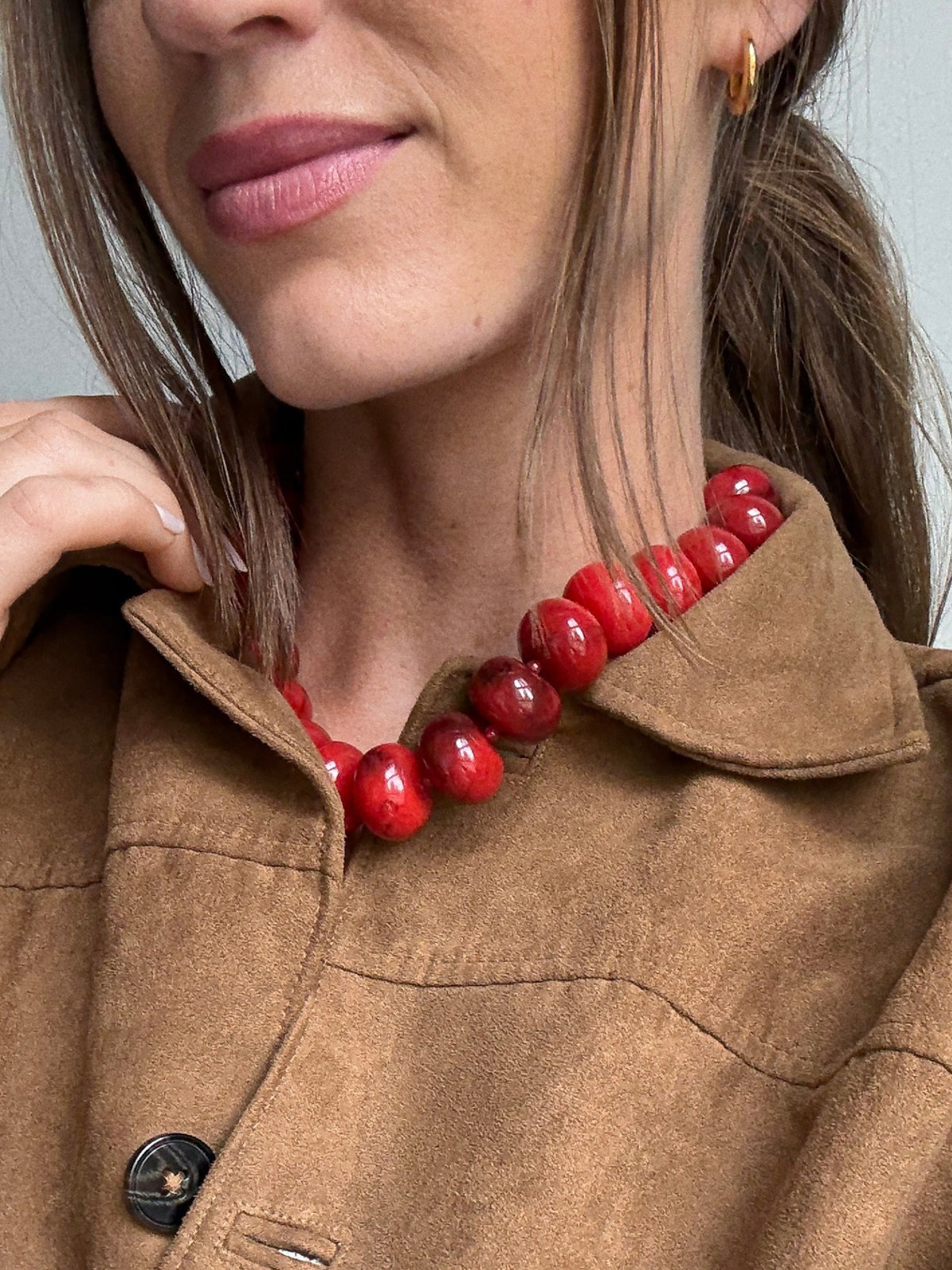BaubleBar Joan Semi-Precious Necklace in Red worn with a brown collared jacket