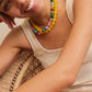 BaubleBar Joyce necklace in Multi layered with a yellow necklace on a model