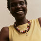 BaubleBar Mini Jane Beaded Necklace in Brown Multi layered with a separate pendant necklace on a model