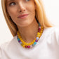 Model wearing the BaubleBar Mini Jane Beaded Necklace in Multi layered with a yellow necklace over a white top.