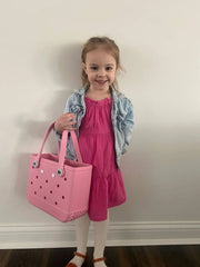 Our adorable little model, displaying the size of a bitty Bogg® Bag tote.