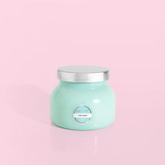 Petite size candle in the color aqua from the brand Capri Blue. The candle is 8 oz. It offers scents of sugared citrus and tropical fruits.