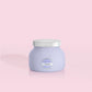 Petite size candle in the color lavender from the brand Capri Blue. The candle is 8 oz and offers a PUNCH of tropical fruits and sugared citrus.