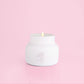 White petite candle from the brand Capri Blue. This candle comes from the Capri Blue Volcano collection. It offers a tropical scent, and is 8 oz.
