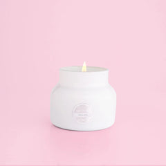 White petite candle from the brand Capri Blue. This candle comes from the Capri Blue Volcano collection. It offers a tropical scent, and is 8 oz.