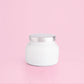 White petite candle from the brand Capri Blue. This candle comes from the Capri Blue Volcano collection. It offers a tropical scent, and is 8 oz.
