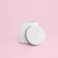White petite candle from the brand Capri Blue. This candle comes from the Capri Blue Volcano collection. It offers a tropical scent, and is 8 oz.