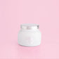 White petite candle from the brand Capri Blue. This candle comes from the Capri Blue Volcano collection. It offers a tropical scent, and is 8 oz.