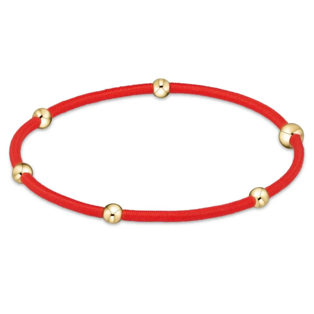 Red colored bracelet with gold beads from Enewton.