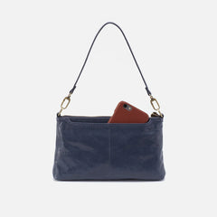 Darcy Crossbody bag designed out of polished leather in the color blue stone. This crossbody is from the handbag brand HOBO.