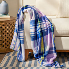 A Vera Bradley Plush Throw Blanket In Amethyst Plaid Pattern, resting on the arm of a couch.