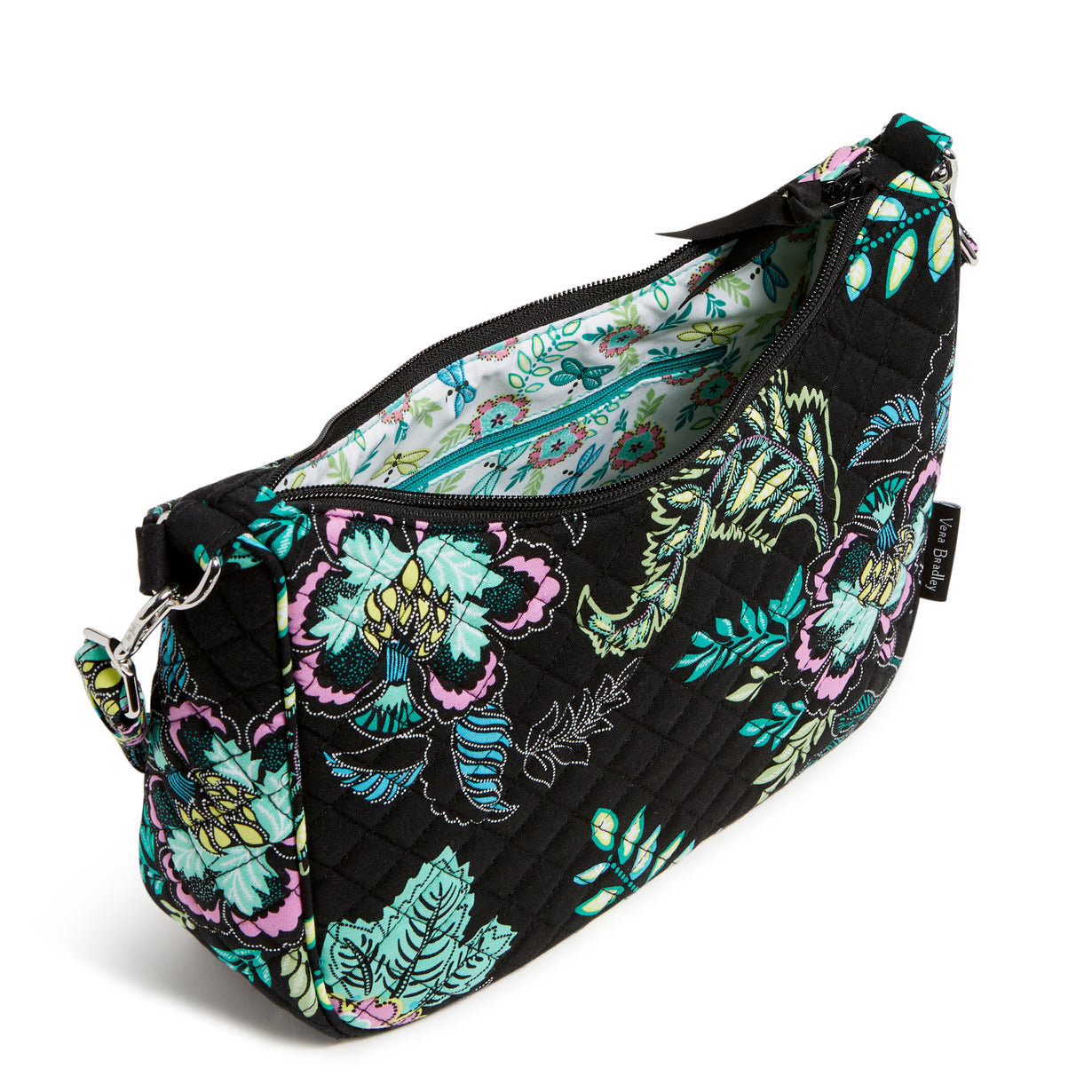 A Vera Bradley Frannie Crescent Crossbody In Island Garden Pattern, with the main pocket unzipped.