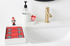 Towel holder displayed by a sink with a Christmas elf displayed on top